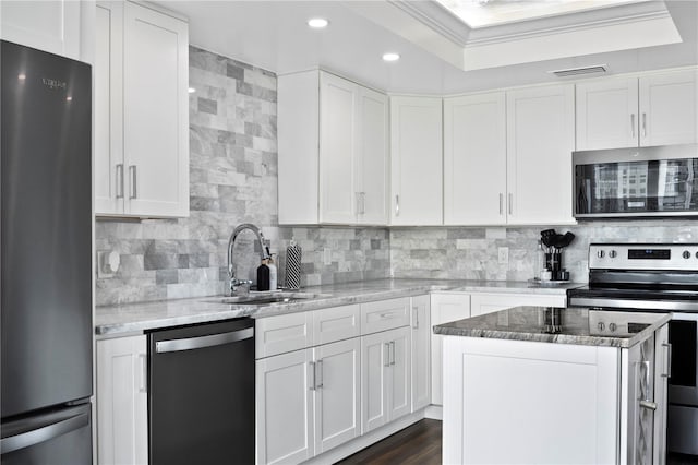 1501 Gulf Blvd Unit 201, Clearwater Beach, FL 33767 - kitchen featuring stainless steel appliances, decorative backsplash, light stone countertops, white cabinetry, and crown molding