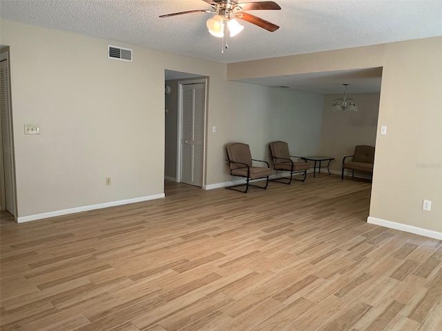 7821 Niagara Ave Unit 2102, Tampa, FL 33617 - living area with a ceiling fan, light wood-style floors, baseboards, and a textured ceiling