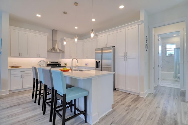 803 Oak Bend Ln, Dunedin, FL 34698 - kitchen featuring wall chimney exhaust hood, appliances with stainless steel finishes, white cabinetry, a kitchen island with sink, and recessed lighting