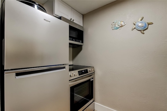 282 Treasure Island Cswy Unit 12, Treasure Island, FL 33706 - kitchen with appliances with stainless steel finishes and white cabinets
