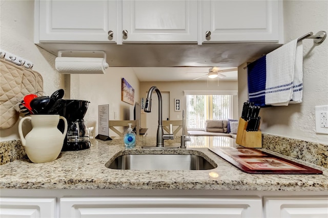 282 Treasure Island Cswy Unit 12, Treasure Island, FL 33706 - kitchen with white cabinetry, ceiling fan, light stone countertops, and open floor plan