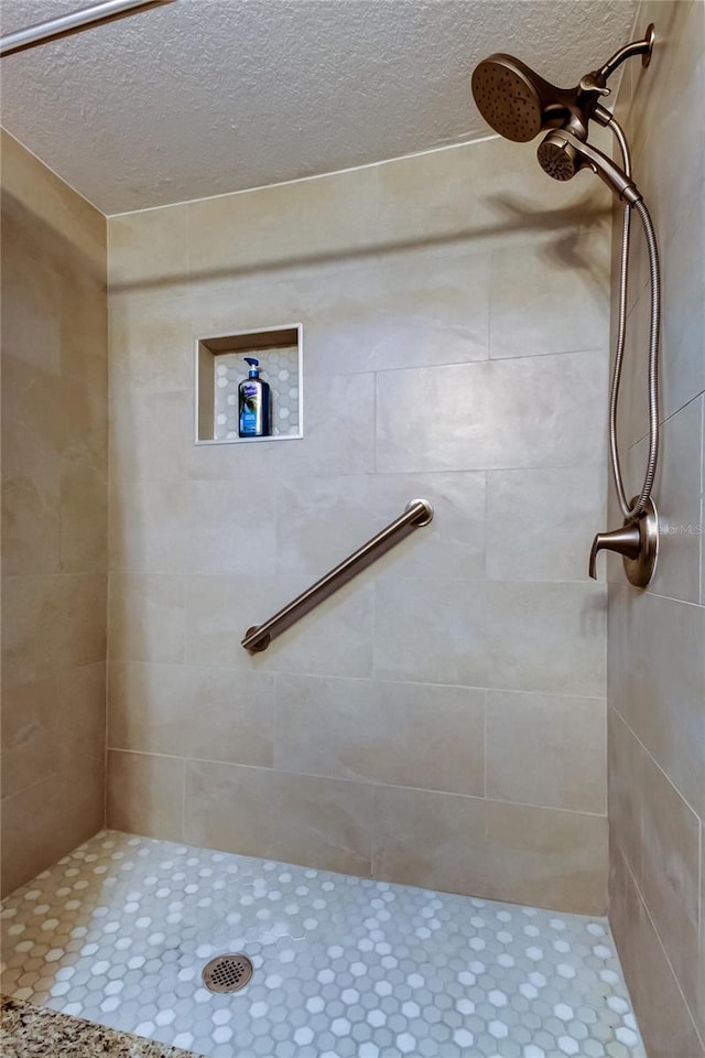 282 Treasure Island Cswy Unit 12, Treasure Island, FL 33706 - bathroom featuring a textured ceiling and a tile shower