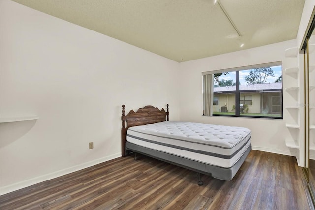 1206 10th Cir SE, Largo, FL 33771 - bedroom featuring track lighting, dark wood-style floors, and a textured ceiling