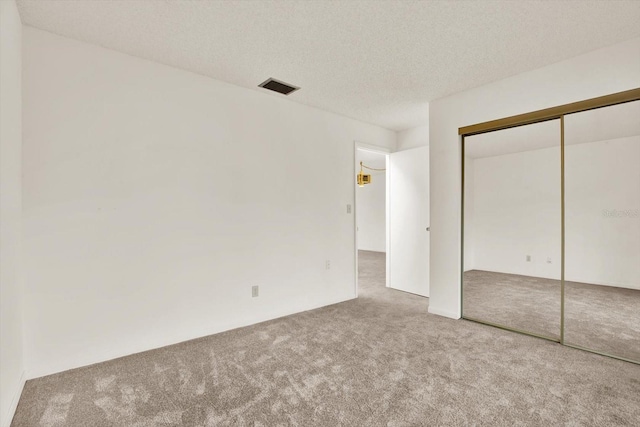 1206 10th Cir SE, Largo, FL 33771 - unfurnished bedroom with carpet floors, a closet, and a textured ceiling