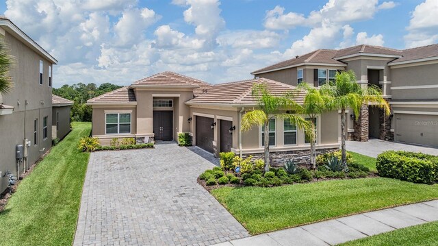 3197 Acacia Bay Ave, Wesley Chapel, FL 33543 - view of front of property with an attached garage, decorative driveway, stucco siding, and a tiled roof