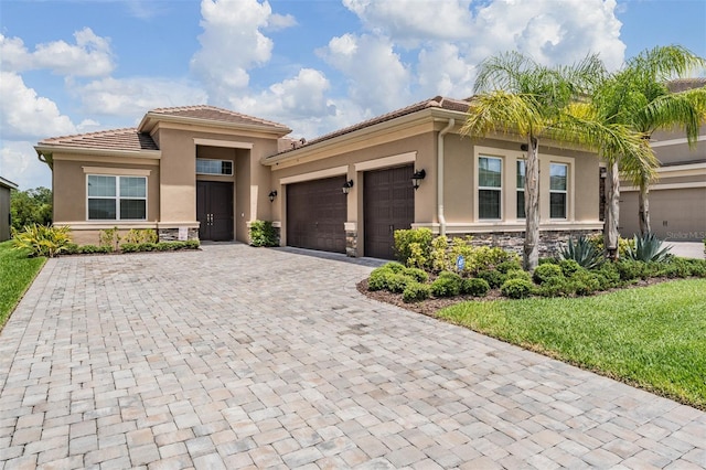 3197 Acacia Bay Ave, Wesley Chapel, FL 33543 - view of front of house with decorative driveway, stucco siding, a garage, stone siding, and a front yard
