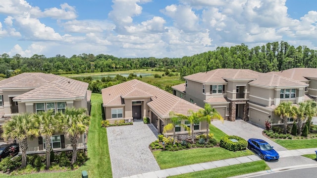 3197 Acacia Bay Ave, Wesley Chapel, FL 33543 - mediterranean / spanish-style home featuring decorative driveway, stucco siding, a tiled roof, stone siding, and a garage