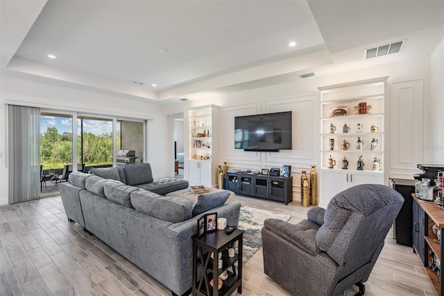 3197 Acacia Bay Ave, Wesley Chapel, FL 33543 - living room featuring a tray ceiling, light wood-style floors, and recessed lighting