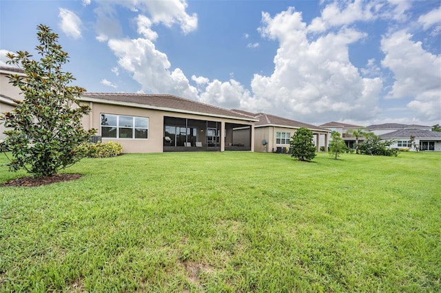 3197 Acacia Bay Ave, Wesley Chapel, FL 33543 - back of house with a lawn, stucco siding, and a sunroom
