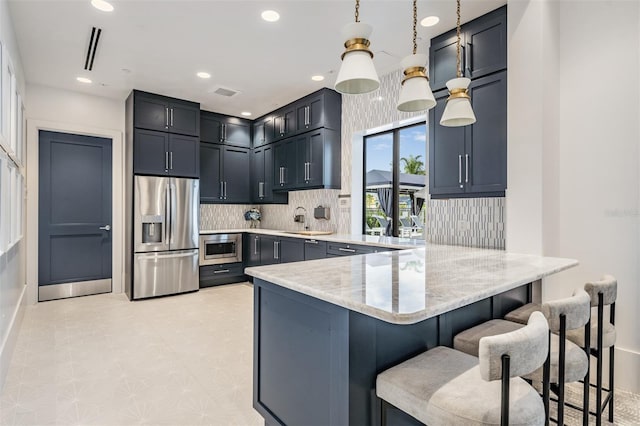 3197 Acacia Bay Ave, Wesley Chapel, FL 33543 - kitchen featuring stainless steel appliances, a peninsula, backsplash, a kitchen breakfast bar, and light stone countertops