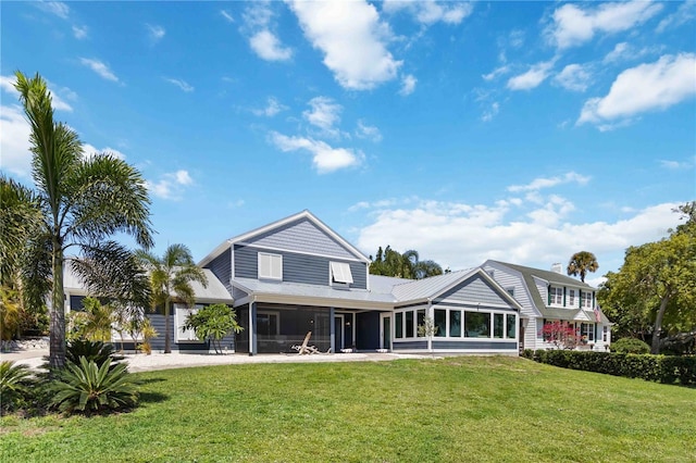 711 N Indian River Dr, Cocoa, FL 32922 - back of house featuring a sunroom and a yard