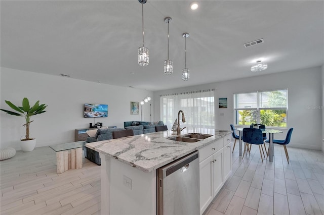 5415 Limelight Dr, Apollo Beach, FL 33572 - kitchen featuring stainless steel dishwasher, light stone counters, a center island with sink, white cabinetry, and hanging light fixtures