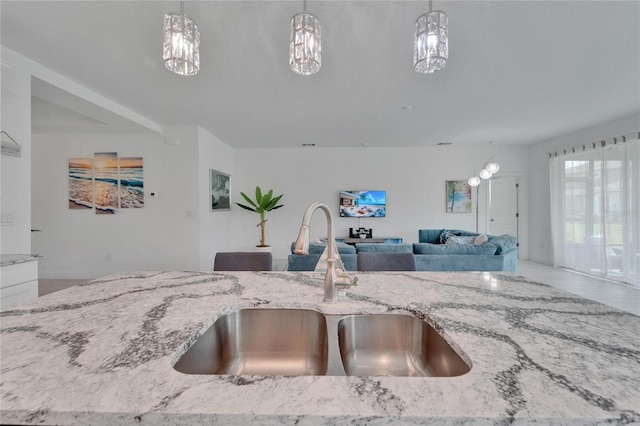 5415 Limelight Dr, Apollo Beach, FL 33572 - kitchen featuring open floor plan, light stone counters, and pendant lighting