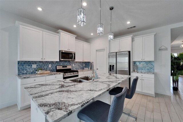 5415 Limelight Dr, Apollo Beach, FL 33572 - kitchen with appliances with stainless steel finishes, decorative backsplash, white cabinetry, and recessed lighting
