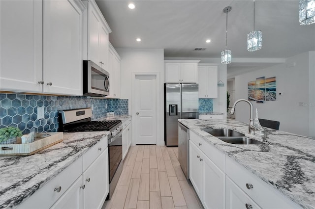 5415 Limelight Dr, Apollo Beach, FL 33572 - kitchen featuring appliances with stainless steel finishes, tasteful backsplash, white cabinetry, decorative light fixtures, and recessed lighting