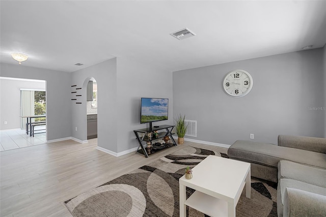 2481 12th Ave SW, Largo, FL 33770 - living room featuring arched walkways and light wood-style floors