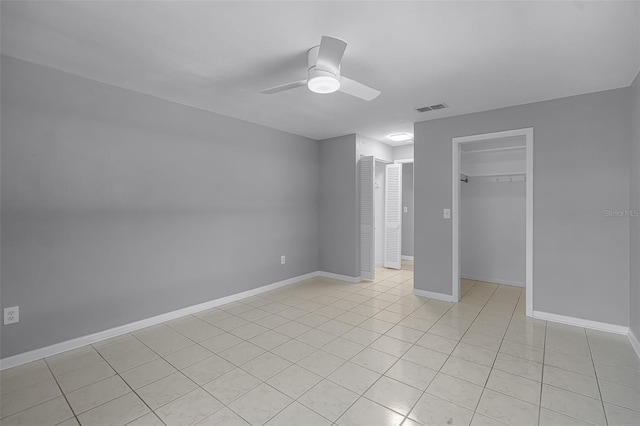 2481 12th Ave SW, Largo, FL 33770 - unfurnished bedroom featuring light tile patterned flooring, a ceiling fan, and multiple closets