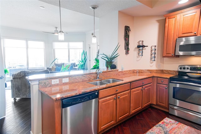 1209 E Cumberland Ave Unit 1003, Tampa, FL 33602 - kitchen with appliances with stainless steel finishes, a peninsula, light stone counters, dark wood-style floors, and hanging light fixtures