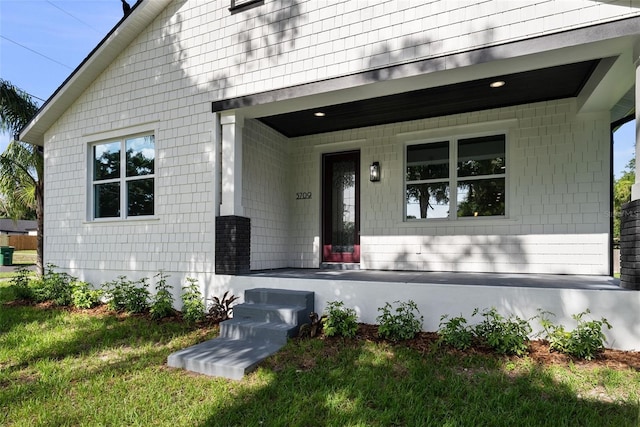 5709 N 20th St, Tampa, FL 33610 - view of exterior entry with a porch and a lawn