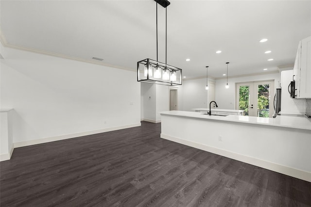 5709 N 20th St, Tampa, FL 33610 - kitchen with recessed lighting, a peninsula, white cabinetry, light countertops, and crown molding