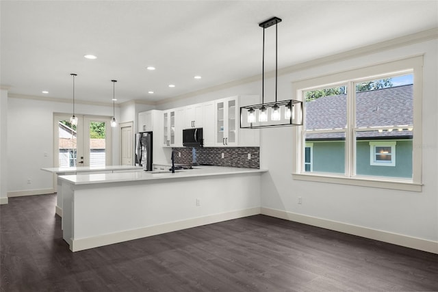 5709 N 20th St, Tampa, FL 33610 - kitchen with black microwave, freestanding refrigerator, a peninsula, glass insert cabinets, and light countertops