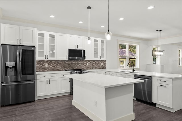 5709 N 20th St, Tampa, FL 33610 - kitchen with appliances with stainless steel finishes, a peninsula, backsplash, glass insert cabinets, and crown molding