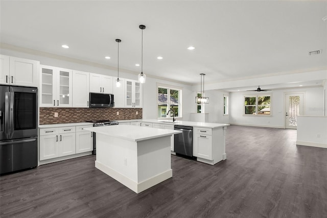 5709 N 20th St, Tampa, FL 33610 - kitchen with stainless steel appliances, a peninsula, a center island, open floor plan, and decorative backsplash