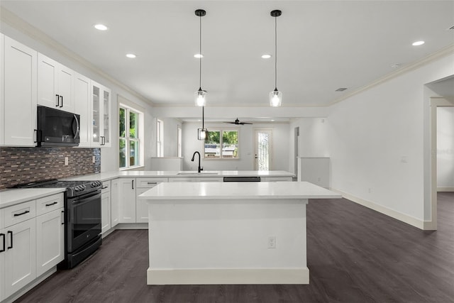 5709 N 20th St, Tampa, FL 33610 - kitchen featuring black appliances, a peninsula, crown molding, dark wood-style flooring, and glass insert cabinets