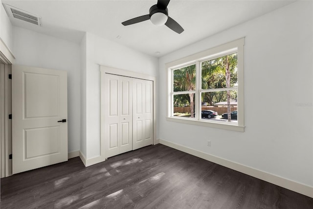 5709 N 20th St, Tampa, FL 33610 - unfurnished bedroom featuring dark wood-type flooring, a closet, and a ceiling fan
