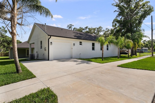 5709 N 20th St, Tampa, FL 33610 - view of home's exterior with an attached garage, concrete driveway, stucco siding, and a yard