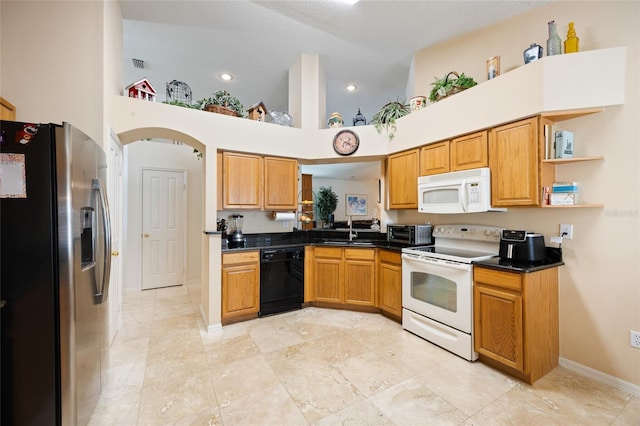 2043 Wrangler Dr, Brandon, FL 33511 - kitchen with white appliances, a sink, a towering ceiling, dark countertops, and baseboards