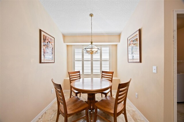 2043 Wrangler Dr, Brandon, FL 33511 - dining area with a chandelier, a textured ceiling, and baseboards