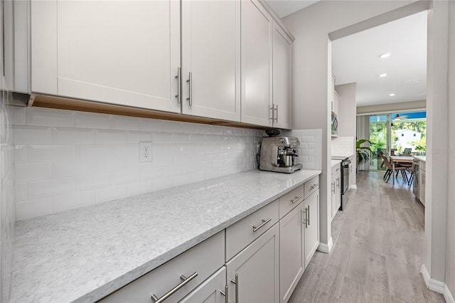 8423 Praise Dr, Tampa, FL 33625 - kitchen with light wood-style floors, backsplash, recessed lighting, light stone countertops, and stainless steel appliances