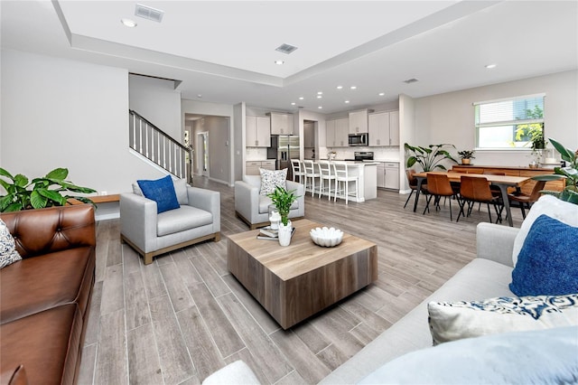 8423 Praise Dr, Tampa, FL 33625 - living area with light wood-style floors, stairway, recessed lighting, and a raised ceiling