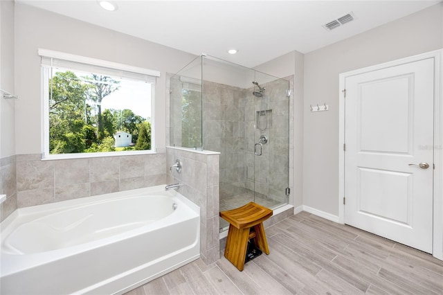 8423 Praise Dr, Tampa, FL 33625 - bathroom featuring a bath, a stall shower, wood finished floors, recessed lighting, and baseboards