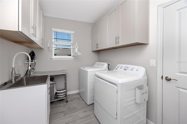 8423 Praise Dr, Tampa, FL 33625 - washroom featuring cabinet space, washer and dryer, baseboards, and wood tiled floors