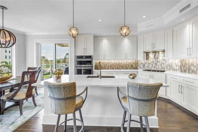 125 Belleview Blvd Unit 203, Belleair, FL 33756 - kitchen with stainless steel double oven, a chandelier, light countertops, crown molding, and decorative backsplash