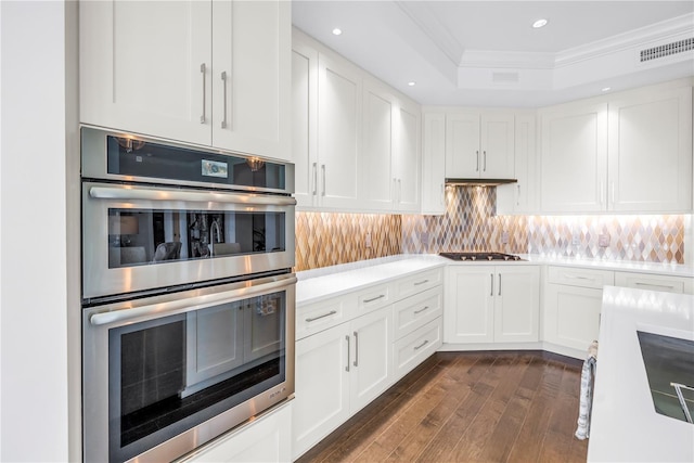 125 Belleview Blvd Unit 203, Belleair, FL 33756 - kitchen with double oven, ornamental molding, gas cooktop, dark wood-style floors, and white cabinets