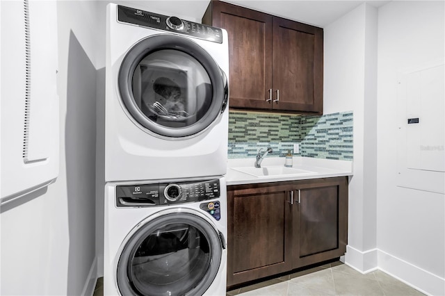 125 Belleview Blvd Unit 203, Belleair, FL 33756 - washroom featuring stacked washer / drying machine, cabinet space, electric panel, and light tile patterned flooring