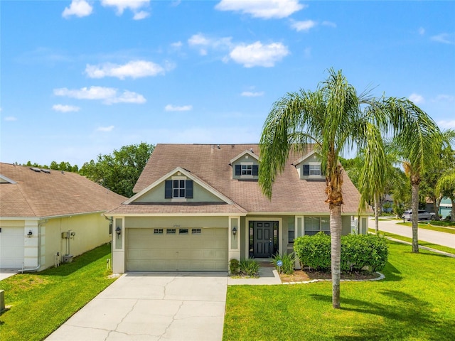 17342 Lawn Orchid Loop, Land O Lakes, FL 34638 - view of front of home featuring stucco siding, driveway, an attached garage, roof with shingles, and a front lawn