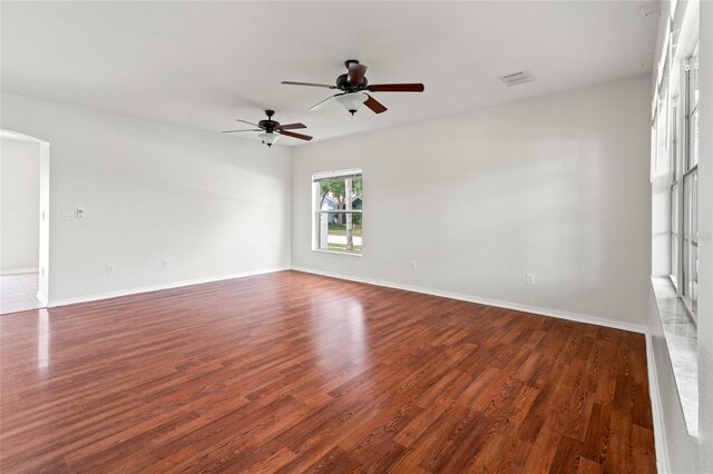 17342 Lawn Orchid Loop, Land O Lakes, FL 34638 - empty room with wood finished floors, ceiling fan, baseboards, and arched walkways