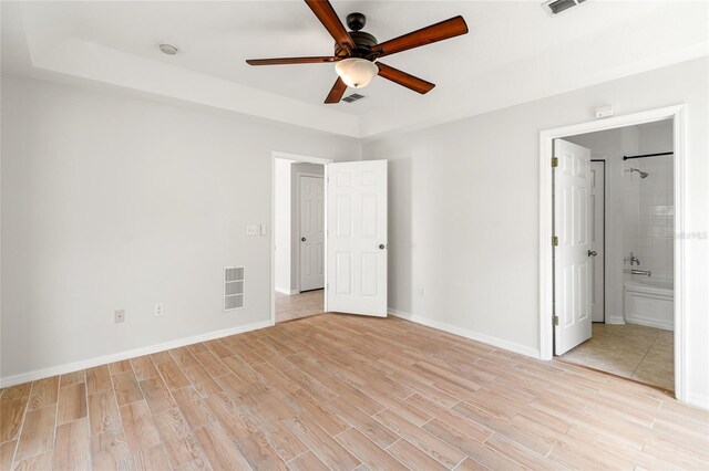 17342 Lawn Orchid Loop, Land O Lakes, FL 34638 - unfurnished bedroom featuring light wood-style flooring, baseboards, ensuite bath, and a ceiling fan