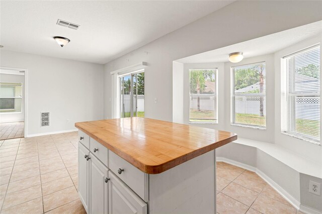 17342 Lawn Orchid Loop, Land O Lakes, FL 34638 - kitchen featuring wood counters, light tile patterned flooring, white cabinets, baseboards, and a kitchen island