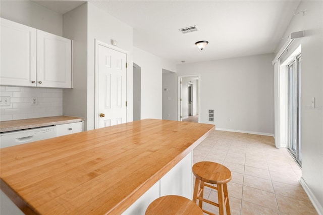 17342 Lawn Orchid Loop, Land O Lakes, FL 34638 - kitchen featuring white cabinets, tasteful backsplash, a breakfast bar area, baseboards, and light tile patterned floors
