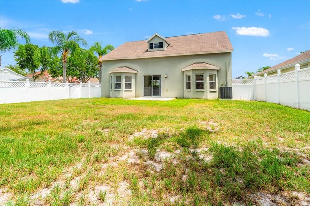17342 Lawn Orchid Loop, Land O Lakes, FL 34638 - back of property featuring stucco siding, central air condition unit, a shingled roof, and a patio