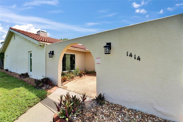 1414 75th St NW, Bradenton, FL 34209 - view of property exterior with stucco siding, a chimney, and a tiled roof