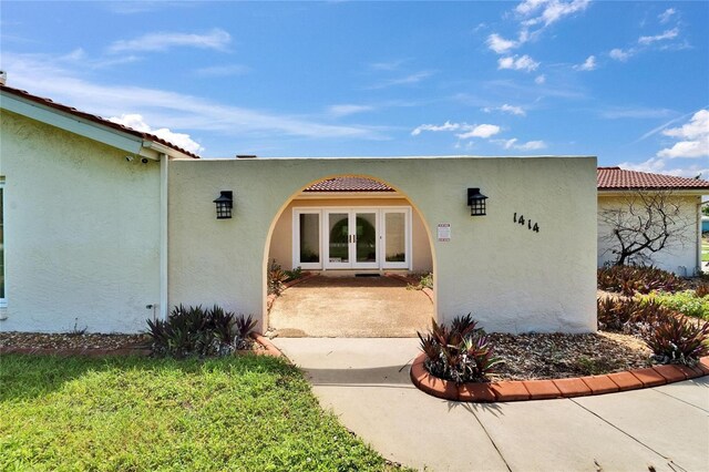 1414 75th St NW, Bradenton, FL 34209 - view of exterior entry with stucco siding, french doors, and a tiled roof
