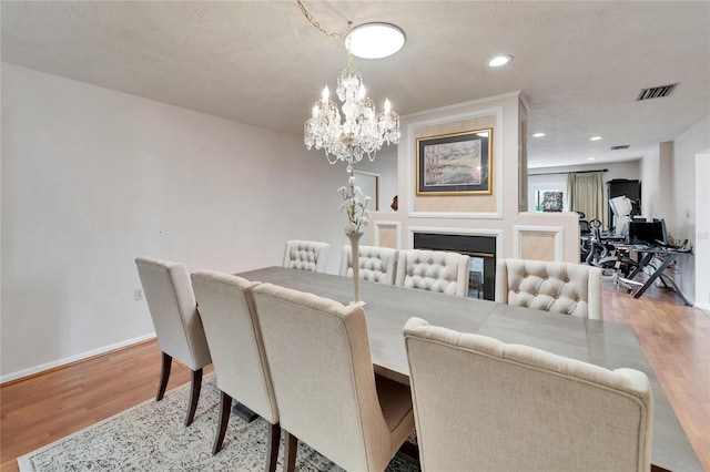 1414 75th St NW, Bradenton, FL 34209 - dining area featuring light wood-style flooring, a chandelier, recessed lighting, and a multi sided fireplace