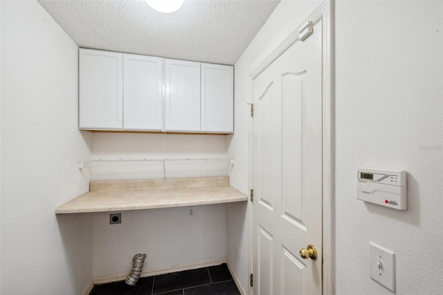 899 Addison Dr NE, Saint Petersburg, FL 33716 - washroom featuring hookup for an electric dryer, cabinet space, a textured ceiling, and tile patterned flooring