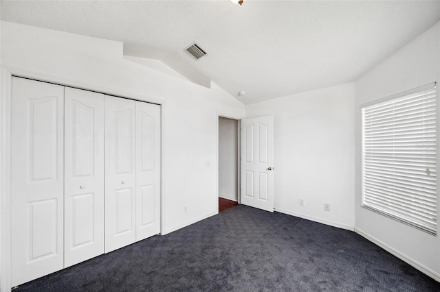 899 Addison Dr NE, Saint Petersburg, FL 33716 - unfurnished bedroom featuring vaulted ceiling, dark carpet, and a closet
